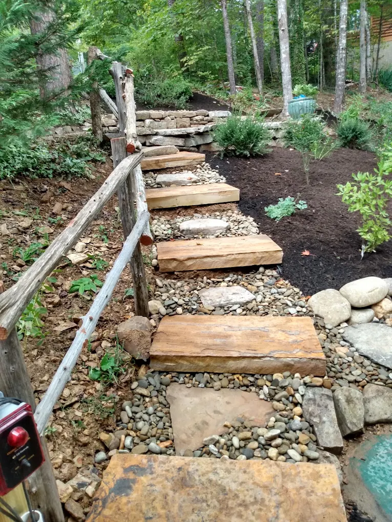 Wooden stepped pathway with gravel edging through wooded garden landscape